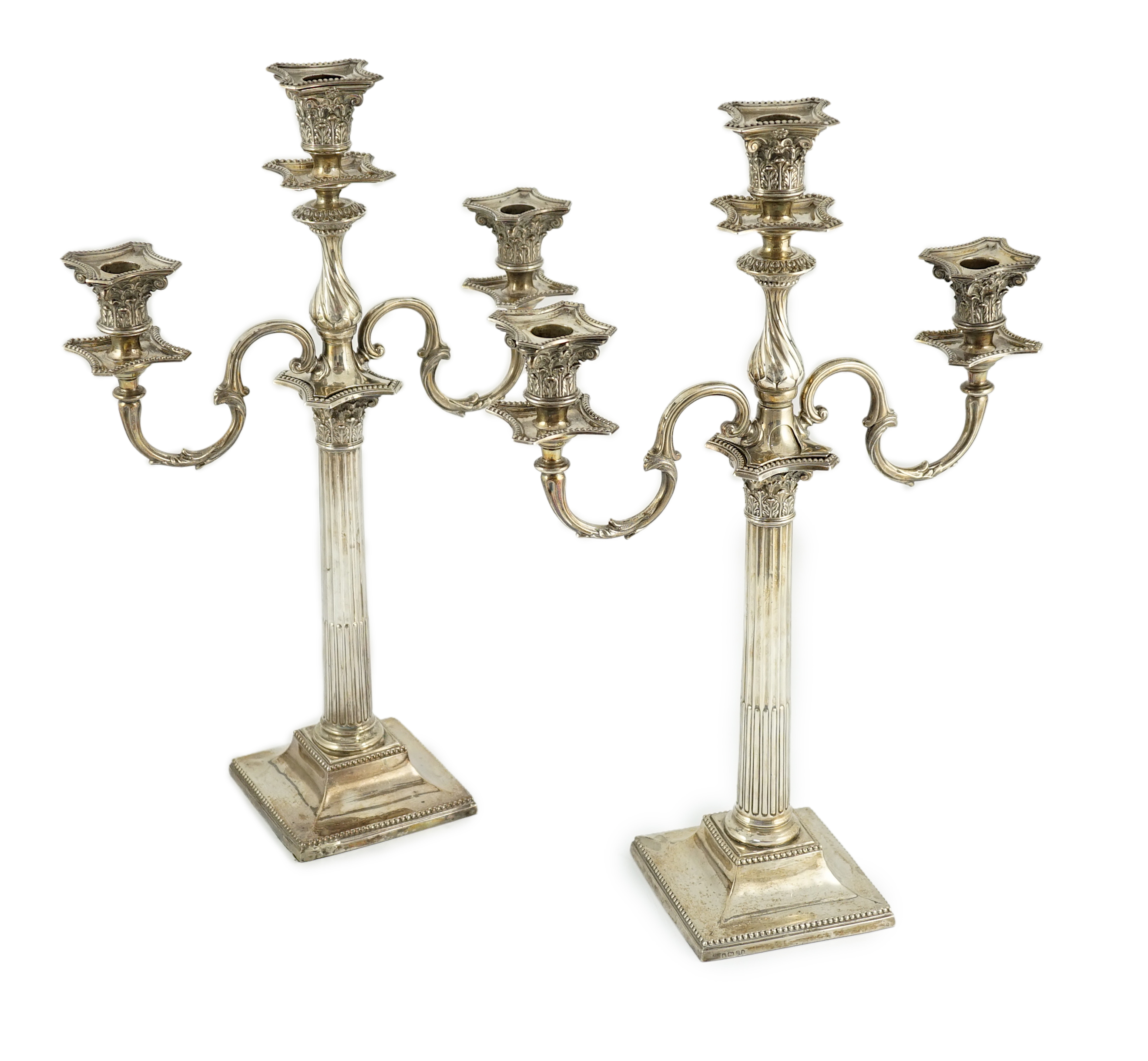 A matched pair of late 19th/early 20th century silver two branch, three light candelabrum